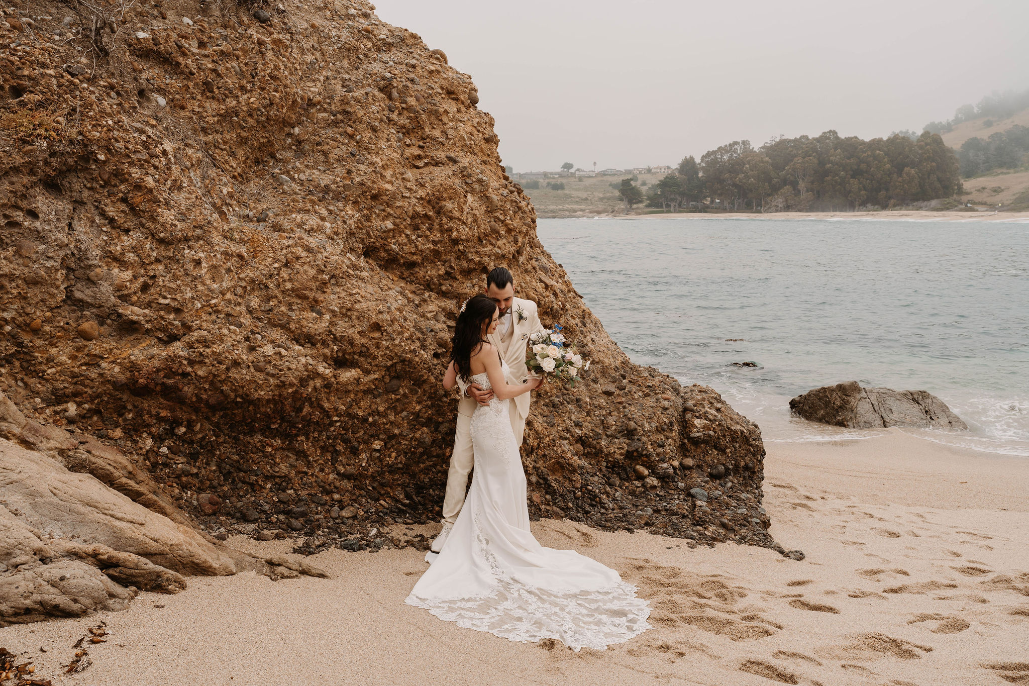 bride and groom posing for their beach wedding